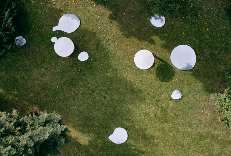 An overhead view of a park filled with white canopies.