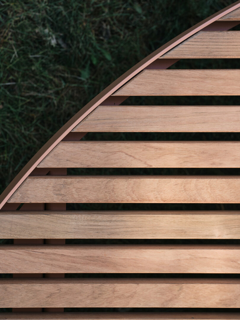 Detail of a modern circular wood bench in a park setting.