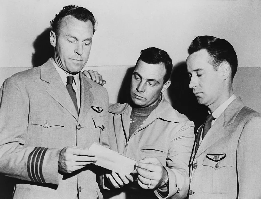 (L-R) Pilots E.J. Smith, Kenneth Arnold and Ralph E. Stevens look at a photo of an unidentified flying object they sighted en route to Seattle, Washington. Credit: Bettmann / Getty Images