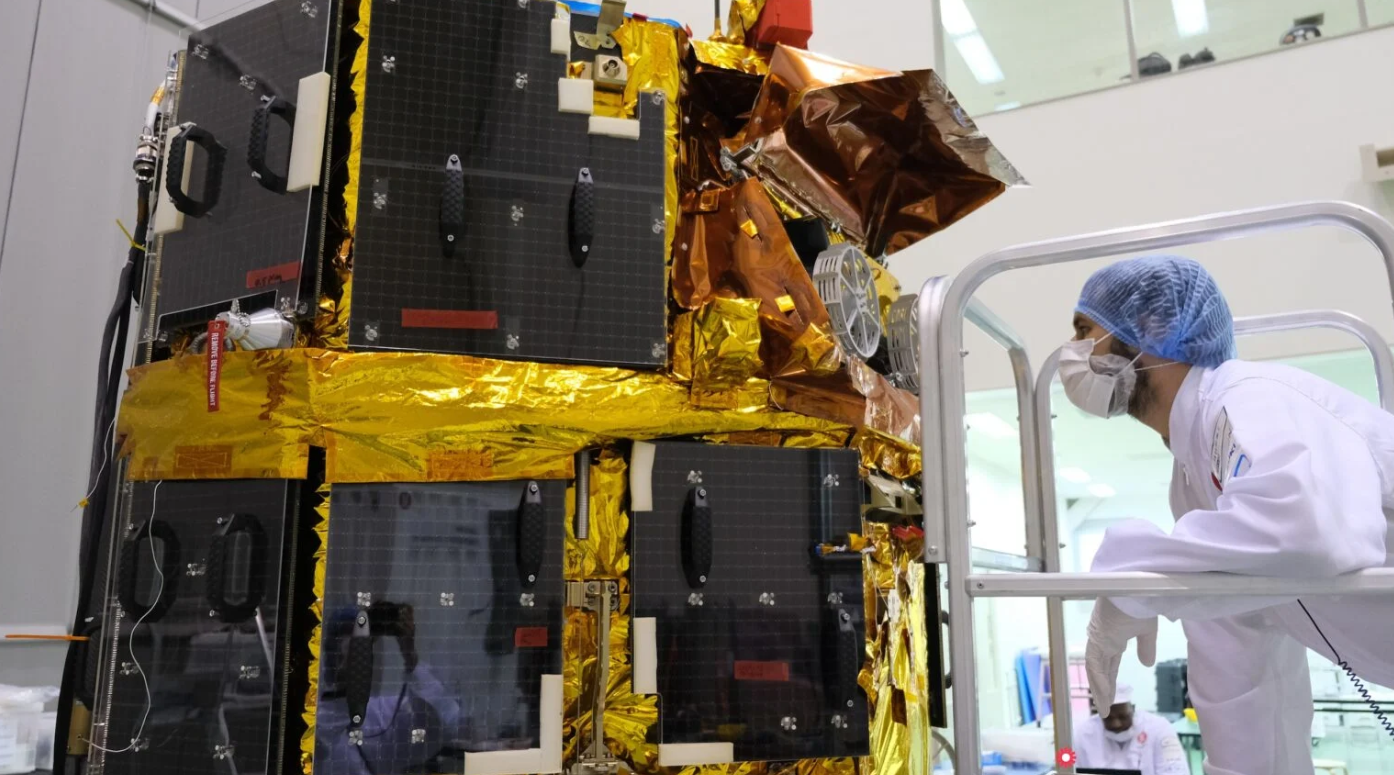 An engineer examines the Tenacious rover mounted aboard the Resilience lander, prior to launch. Credit: ispace