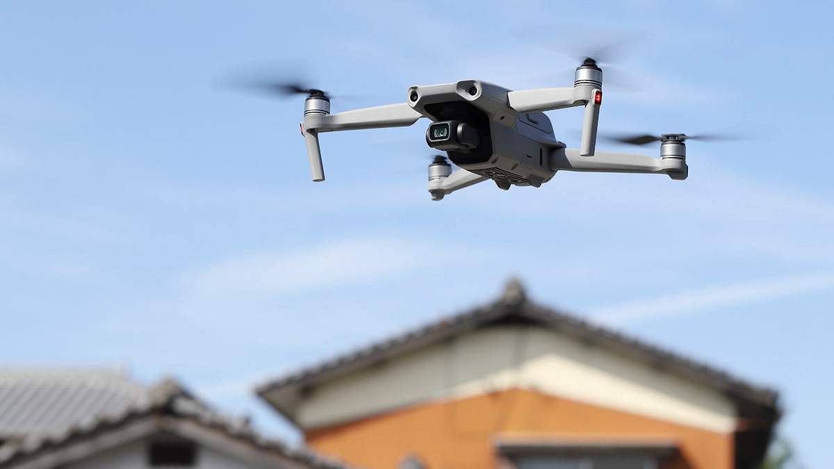A stock image of a drone flying over a home